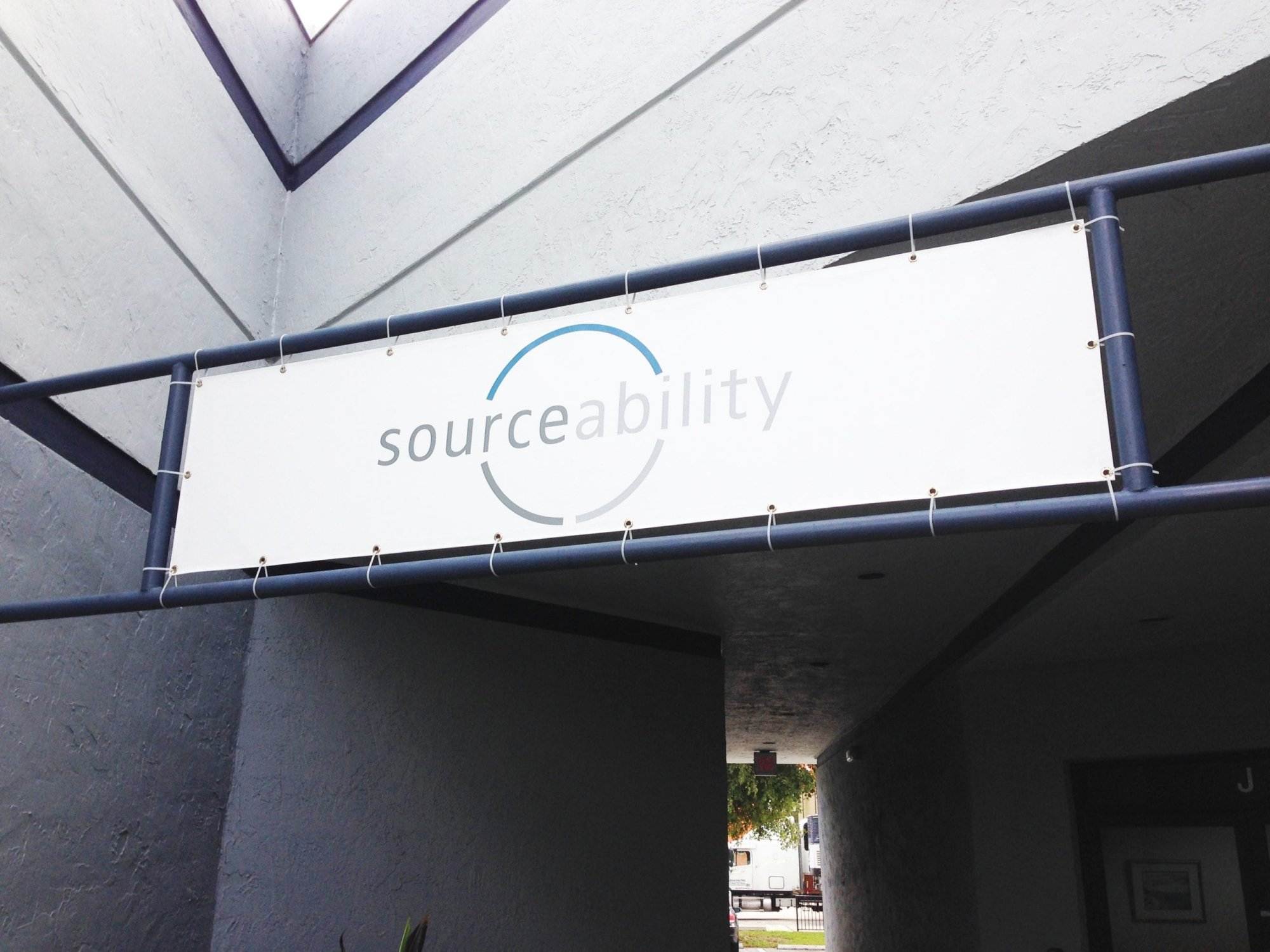 Sourceability Vinyl Banner Mounted Above A Building Entrance