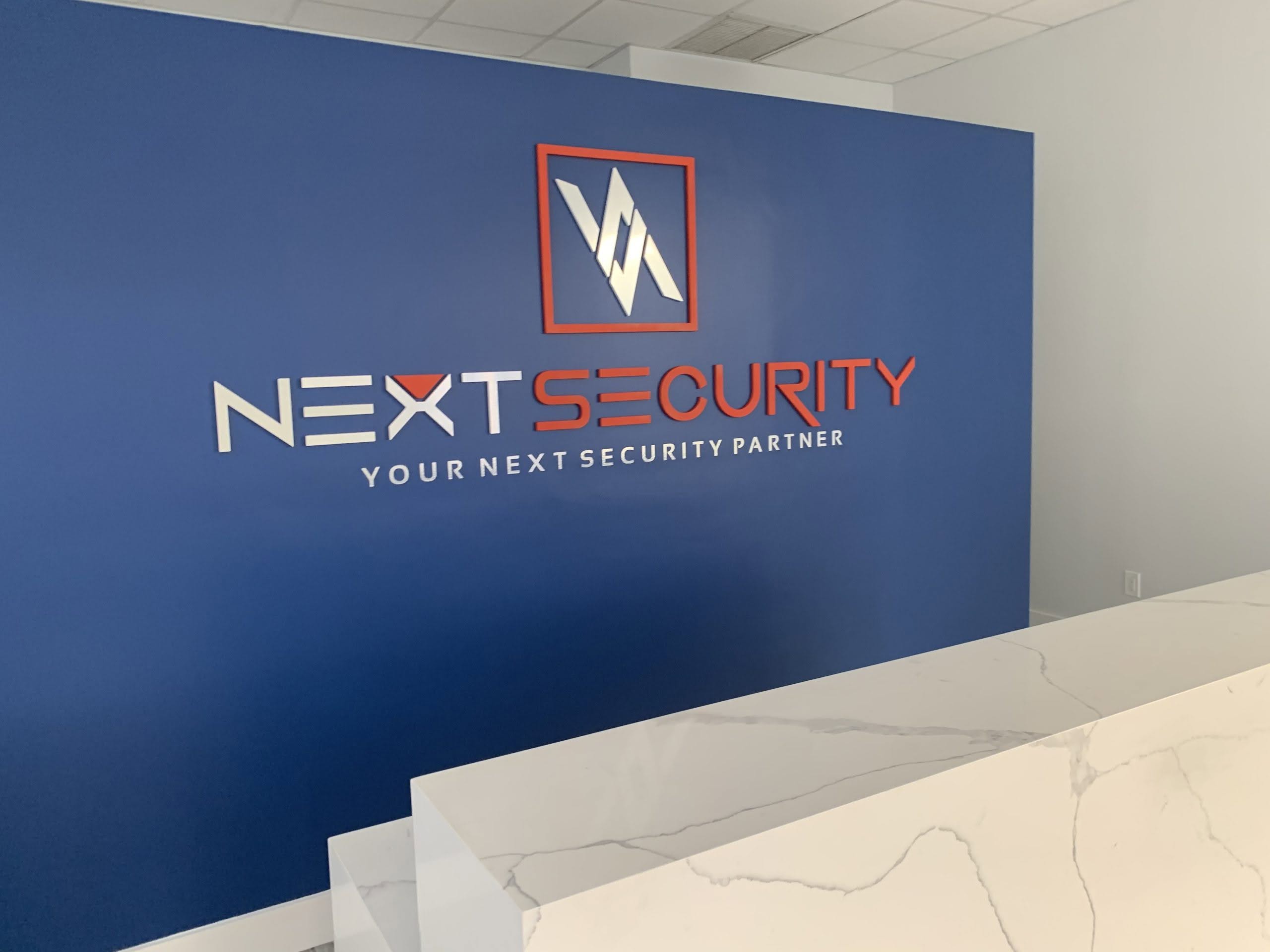 Dimensional Next Security Logo Mounted On A Doral Reception Wall.