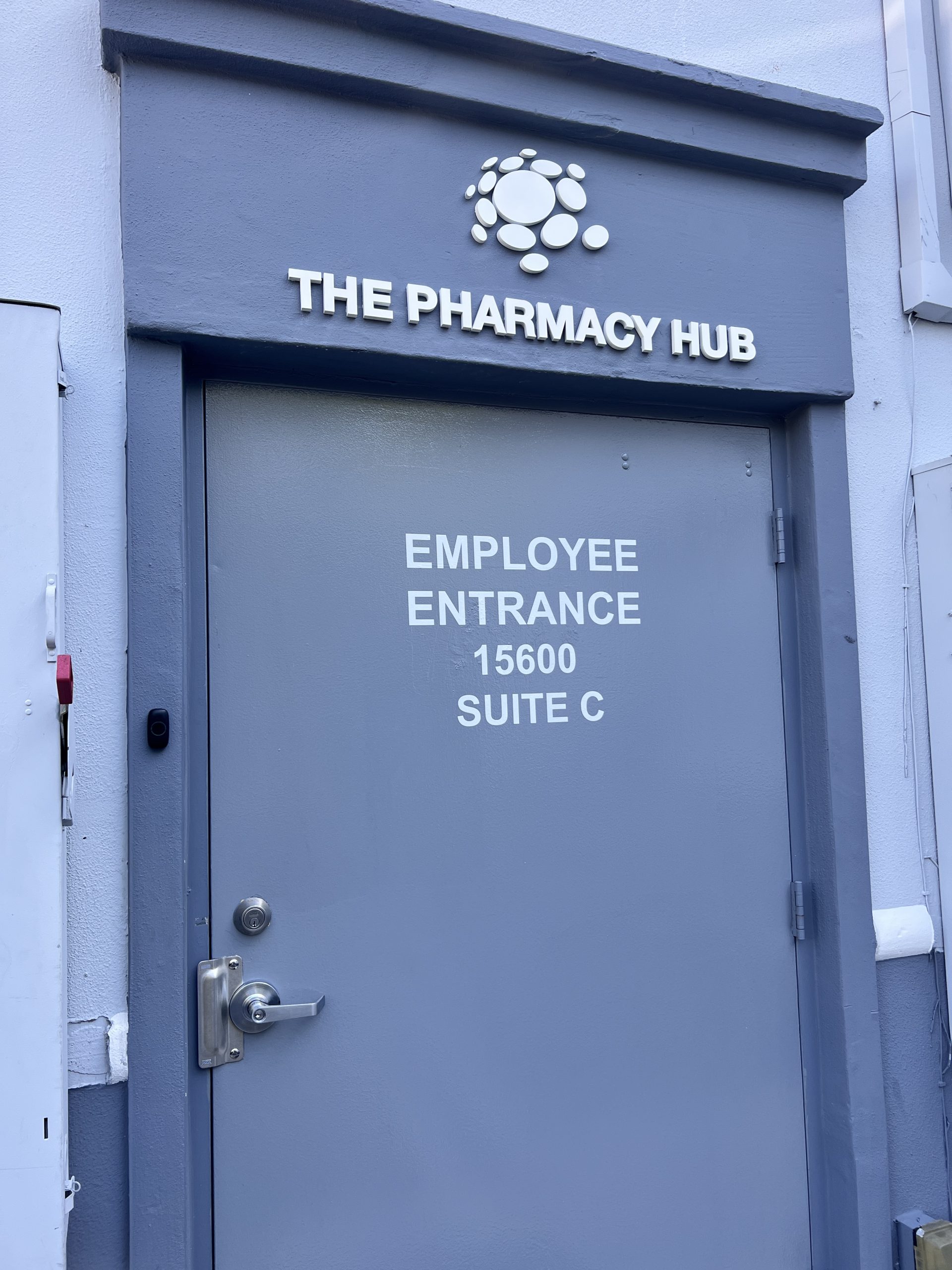 The Pharmacy Hub Pharmacy Signage In Miami Gardens White Employee Entrance Lettering On An Exterior Service Door Beneath A Dimensional Wall Logo