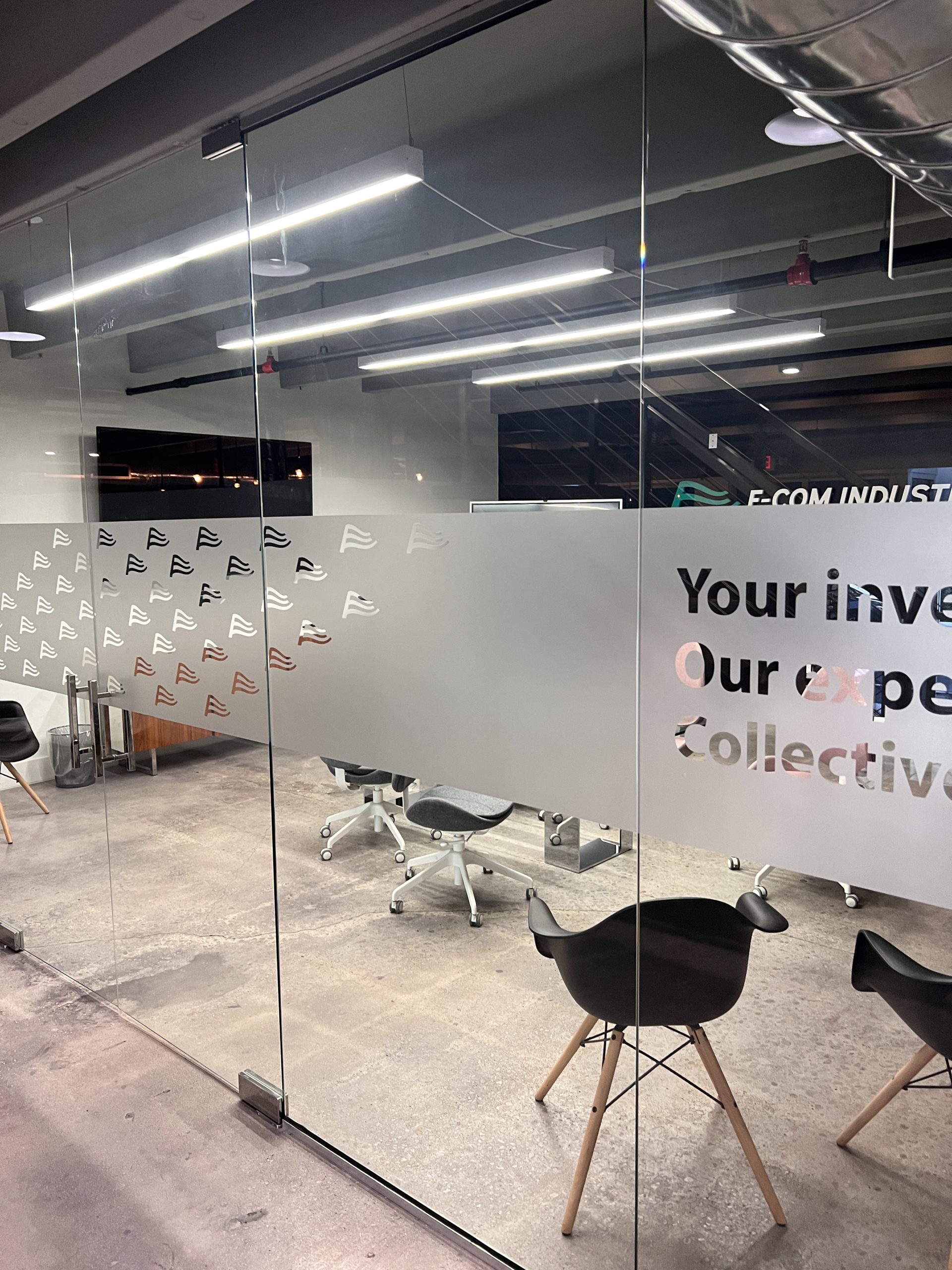 Doral Office Signage And Frosted Glass Graphics | E-Com Industry Frosted Glass Wall With Repeated Wave Marks And Large E-Com Industry Message Lettering