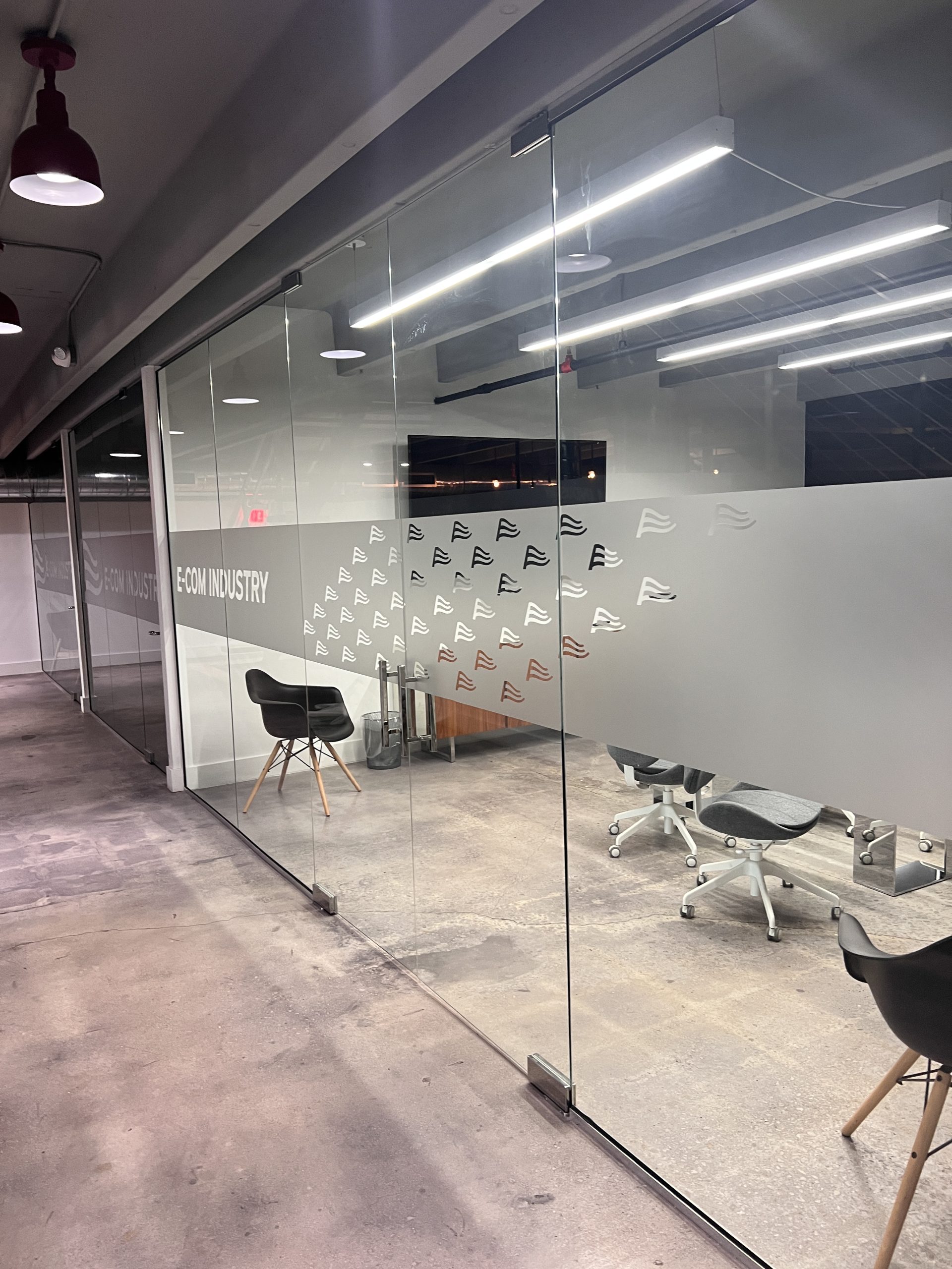Doral Office Signage And Frosted Glass Graphics | E-Com Industry Long Office Hallway Glass Wall With Frosted Privacy Bands And Repeated E-Com Industry Logo Marks