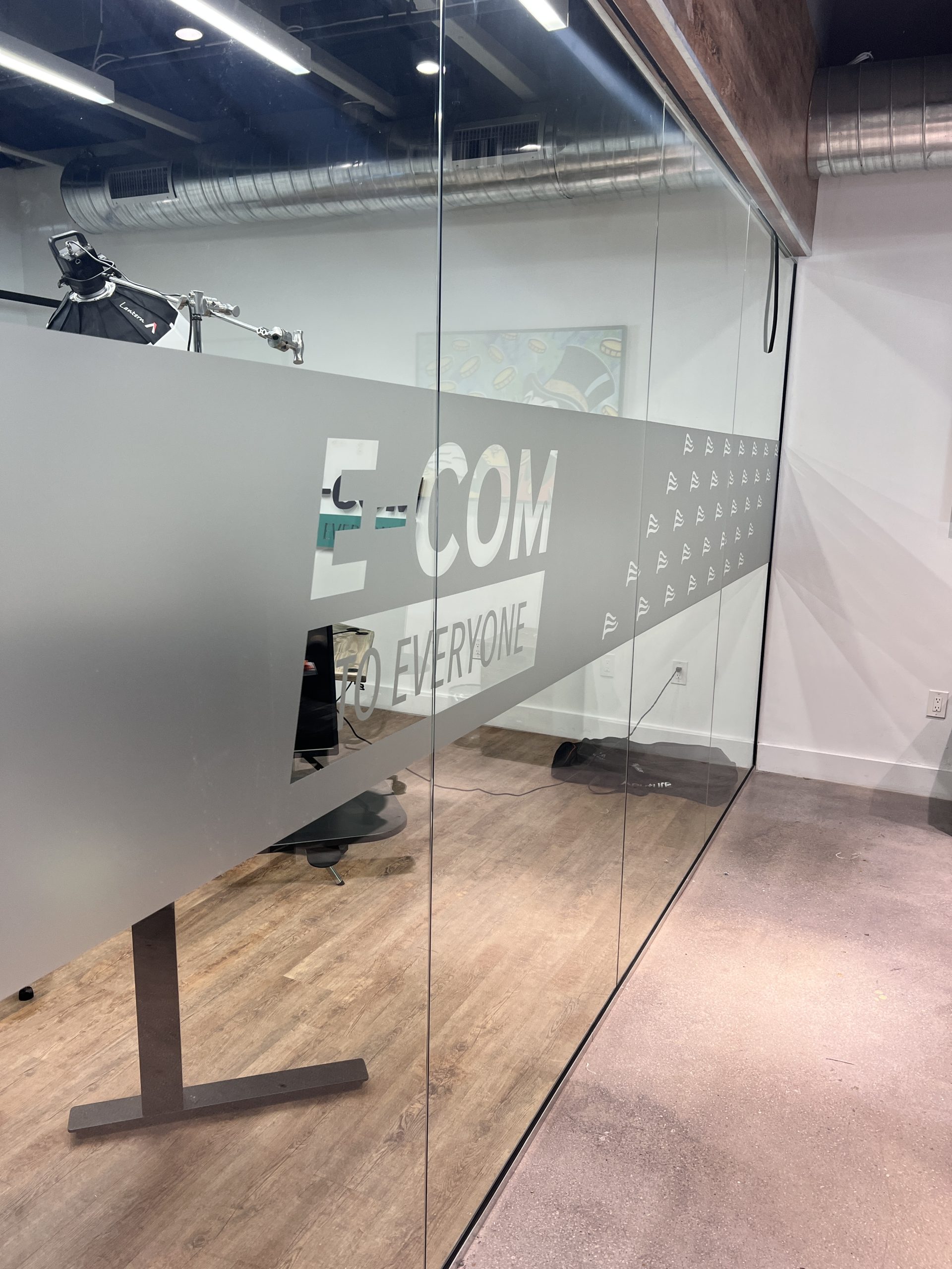 Doral Office Signage And Frosted Glass Graphics | E-Com Industry Office Glass Wall With A Frosted Band, Repeated E-Com Wave Logo Marks, And Cut Lettering