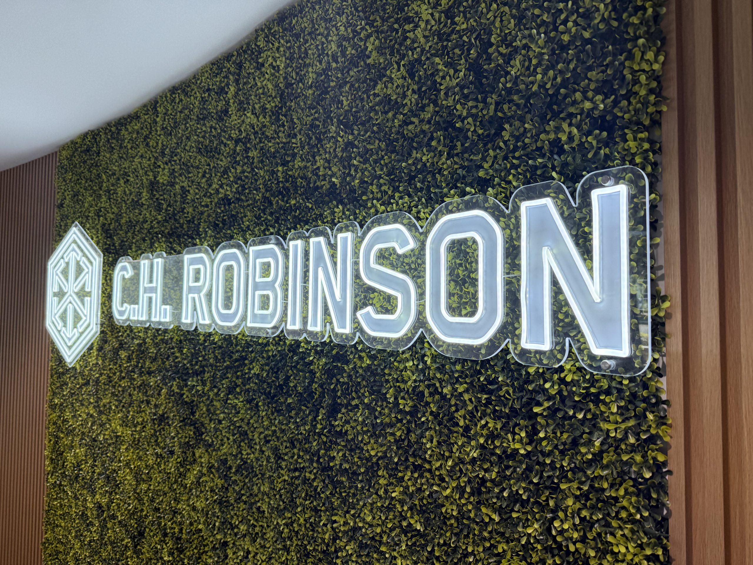 C.h. Robinson Doral Office Signage | Led Neon &Amp; Glass Graphics Wide View Of A Finished Illuminated Led Neon Wall Sign Mounted On A Green Wall Feature